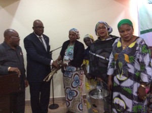 A rural woman hands over a bunch of firewood to Mr. Toure...On extreme right is Mrs. Halima Kolo Mohammed, the RUWES Admin Coordinator