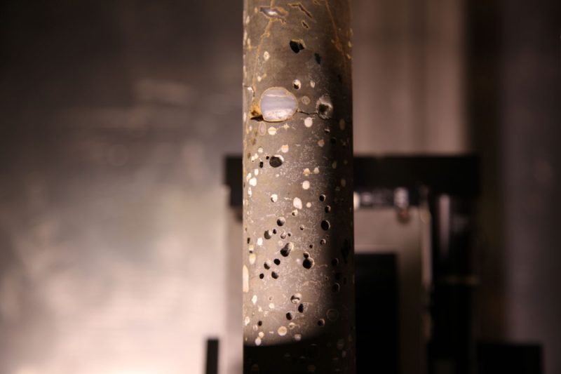 A core sample from research conducted to sequester carbon dioxide in basalt rocks. The white areas within the dark basalt rock core sample show where the carbon dioxide has reacted with minerals in the basalt and converted into a carbonate mineral similar to limestone. Photo credit: Pacific Northwest National Laboratory.